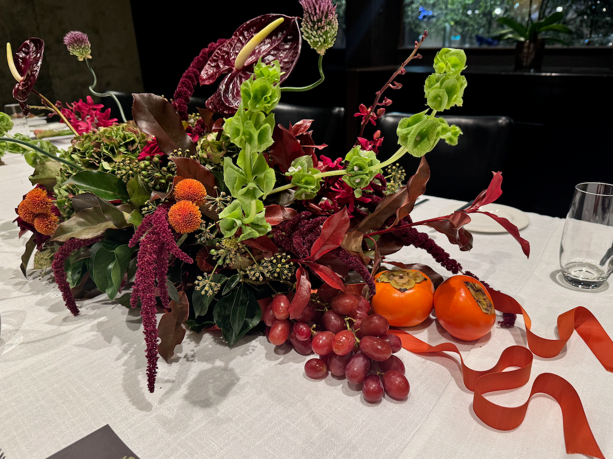 Decorative floral arrangement with fruits on a tablecloth